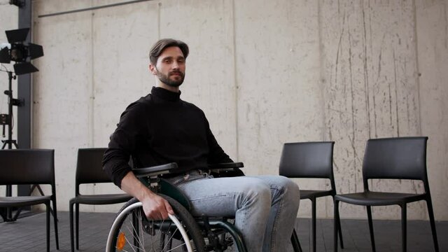 Young man on wheelchair after therapy session, looking at camera.