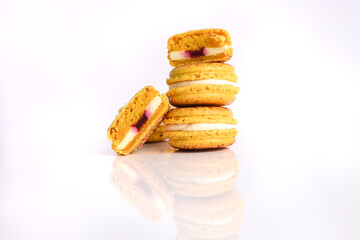 Yellow macaroon with filling on a white background.