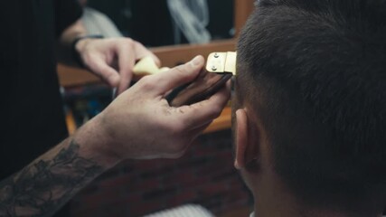 Close up view of barber trimming forehead of client