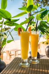 Cocktails or juice from fresh tropical fruits on the background of the sea.