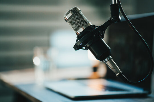 Home studio podcast interior. Microphone, laptop and on air lamp on the table