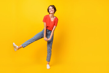 Fototapeta na wymiar Full size photo of cool brunette optimistic lady dance wear red t-shirt jeans sneakers isolated on yellow color background