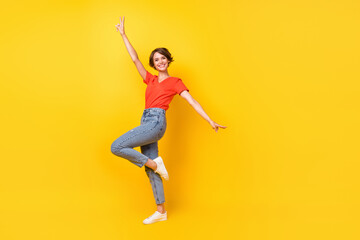 Fototapeta na wymiar Full size profile photo of cool brunette optimistic lady dance wear red t-shirt jeans sneakers isolated on yellow color background
