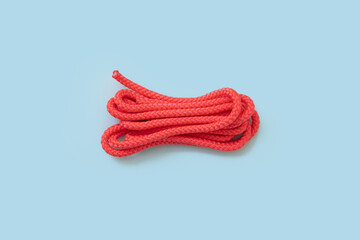 Rope for doing fitness exercises, red rope on light blue background