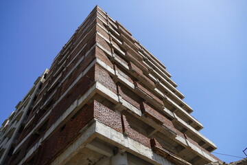 Building under construction against blue sky. General view of the construction of a new residential complex. Partially constructed Multi-storey buildings and high-rises. 