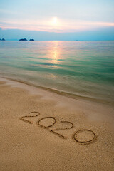 Beach ocean wave with handwritten numbers on the sand.