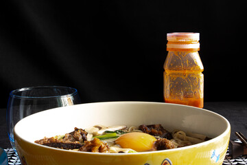 Bowl of asian noodle soup with pork, beef, vegetables and egg