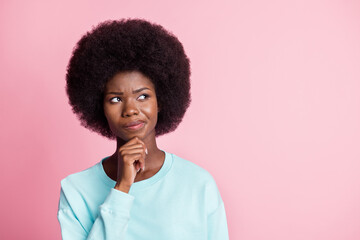 Photo portrait of girl thoughtful touching chin having doubt looking copyspace isolated on pastel pink color background