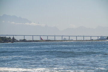 Obraz premium Guanabara Bay, Santos Dumont Airport, Rio x Niteroi Bridge, and the Serra dos Orgaos in the background in Rio de Janeiro, Brazil.