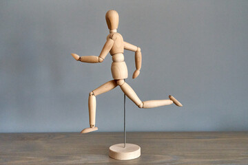 wooden mannequin figure running sideways