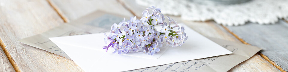 Beautiful fresh violet lilac bouquet in metal can. Greeting card for Mother's day, Saint Valentine's Day, 8 march, Women's day. Springtime freshness. White wooden background, close up banner