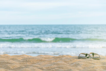 Fototapeta na wymiar Flip-flops on the sand, on the beach, clear sky, space for text