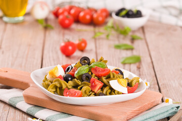 Fusilli pasta with cherry tomatoes, eggs and black olives.