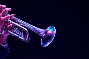 Musician, man playing trumpet, hand close up  black background