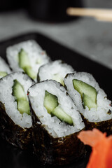 Delicious, juicy and mouth-watering maki with cucumber. Sushi on a gray background