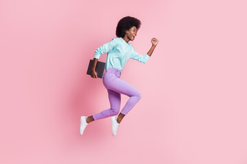 Fototapeta na wymiar Full length photo of sweet pretty dark skin woman dressed colorful outfit jumping holding modern device isolated pink color background