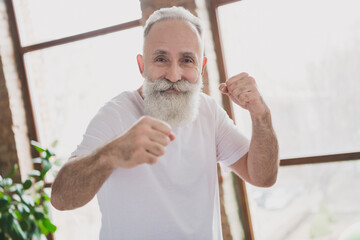 Photo of happy positive good mood smiling grandfather doing karate punching fighting training at home house © deagreez
