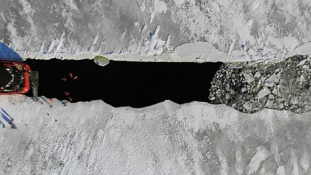 Crews Of An Ice Breaker Vessel Swimming In Ice Cold Water During Winter. aerial drone