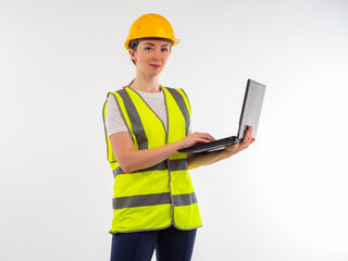 Woman engineer looking at camera. Employee of engineering company. Engineering woman with a laptop in her hands. Engineer in yellow vest and hard hat. Work as engineer. Industrialist with laptop.
