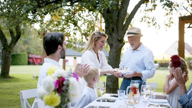 Family having a big garden party and celebrating grandfathers birthday.