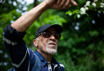 Latino American man in sunglasses likes a flowering branch in spring
