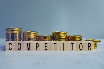 Competitor text on wood block with a pile of coins