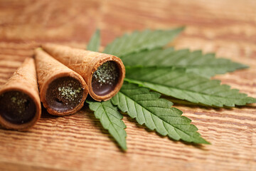 
Sweets with CBD oil. Marijuana buds on wooden background. Cannabis flowers and chocolate cookies...