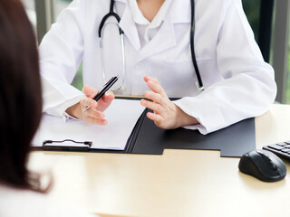 Fototapeta premium A close-up of the hand of a female doctor or nurse holding a pen is talking or explaining information or something for a patient...