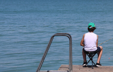 child on the sea pier lonely child sitting in the chair on the jetty