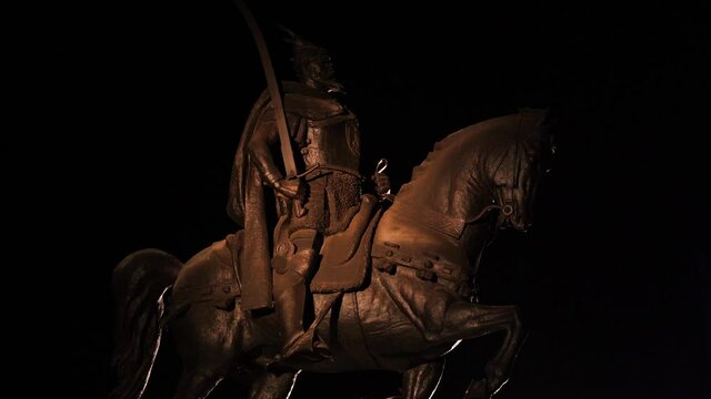 Monument of Albanian national hero Skanderbeg and his horse at night, black background