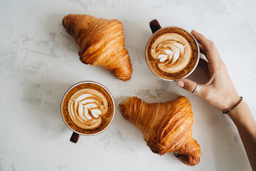 Two cups of coffee and croissant on white table - Powered by Adobe