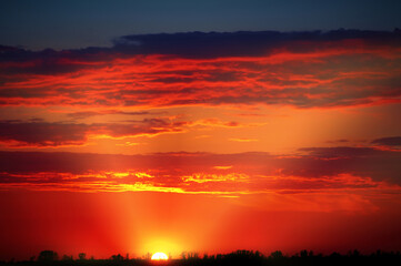 Red dramatic sunset. The last sun rays over cloudscape