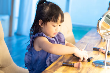 Adorable Asian toddler young makeup artist at studio