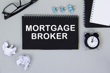 MORTGAGE BROKER. informationon on a black notebook, on a background office table.