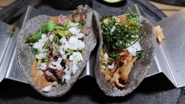 Tacos mexicanos servidos en tortilla azul con cilantro y cebolla