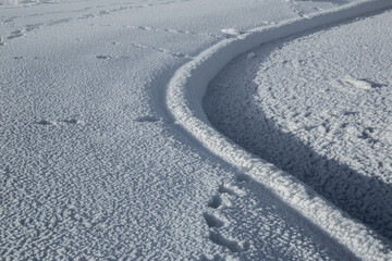 Snow texture. Wind sculpted patterns on snow surface. Winter background