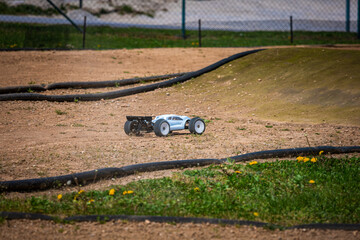 White Radio Controlled (RC) Offroad Truggy on an outdoor track training during sunny day