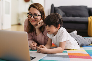 mother and her child enjoying time together at home, using laptop computer