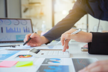 Business people use calculators Computers and graphs showing the results of successful teamwork...