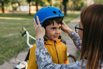 Fototapeta na wymiar mother preparing her son to ride a bike