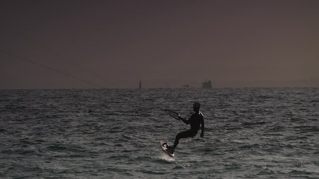 Kiteboarding sport. Kite surfer riding waves, Tarifa Spain. Recreational activity, water sports, action, hobby and fun. Slow motion