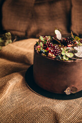 Beautiful brown cake from baker on dark background. Slice of cake. Chocolate and strawberry cake. Dessert on Birthday party. Delicious dessert - rustic and vintage style.