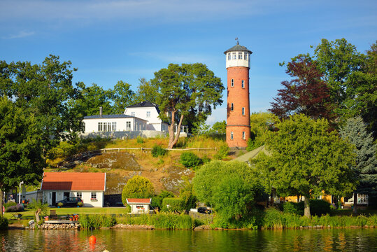 Panoramic view of the forest lakeshore. Traditional houses and old water tower. Balsta, M&auml;laren lake, Sweden. View from a sailing boat. Travel destinations, summer vacations