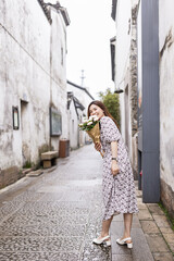 Obraz na płótnie Canvas Portrait of young asian woman wearing stylish summer dress and walking outdoor in old city. Happy stylish woman with smiley face enjoys life