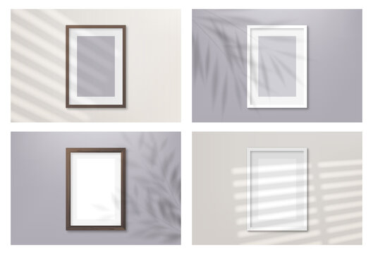 Set of realistic blank picture frames hanging on a light wall from the front with overlay shadows. Design Template for Mock Up.
