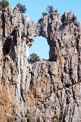 Amazing large hole like an arched window in the cliff along the coast of Palinuro, Italy, Europe. 