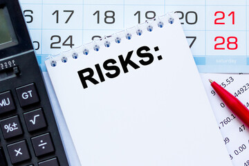 RISKS. The calculator, kalendar, notebook with the text on the financial table. Business, Financial concept