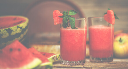 Watermelon on a rustic wooden background. Slices of juicy ripe red watermelon. Fresh juice. Cocktails and soft drinks. Refreshing summer drink.