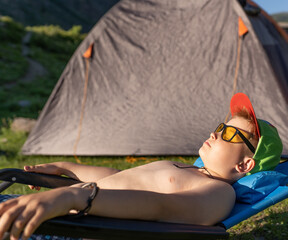 one little boy sunbathing in the mountains