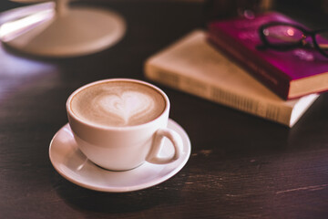 cup of coffee on the wooden table with books